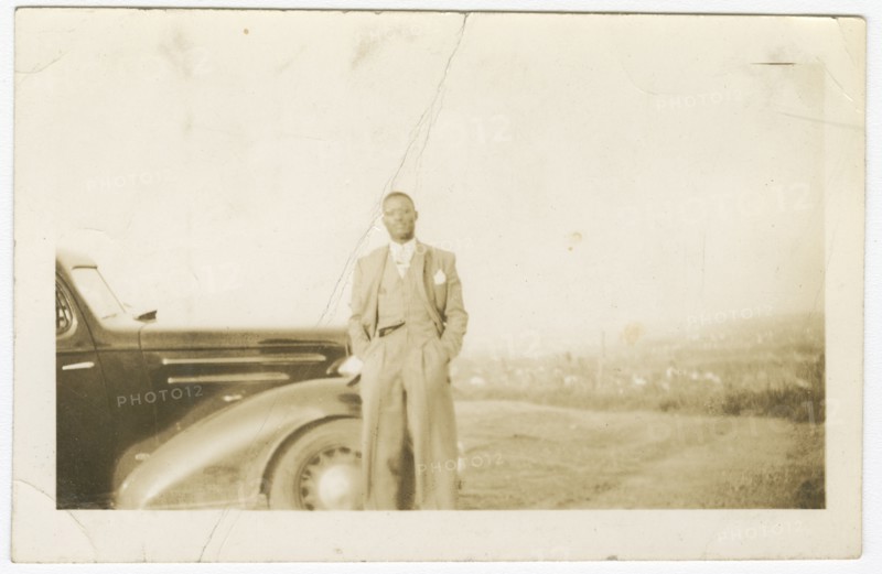 Photograph of an unidentified man in front of car, ca. 1920. Creator: Unknown.