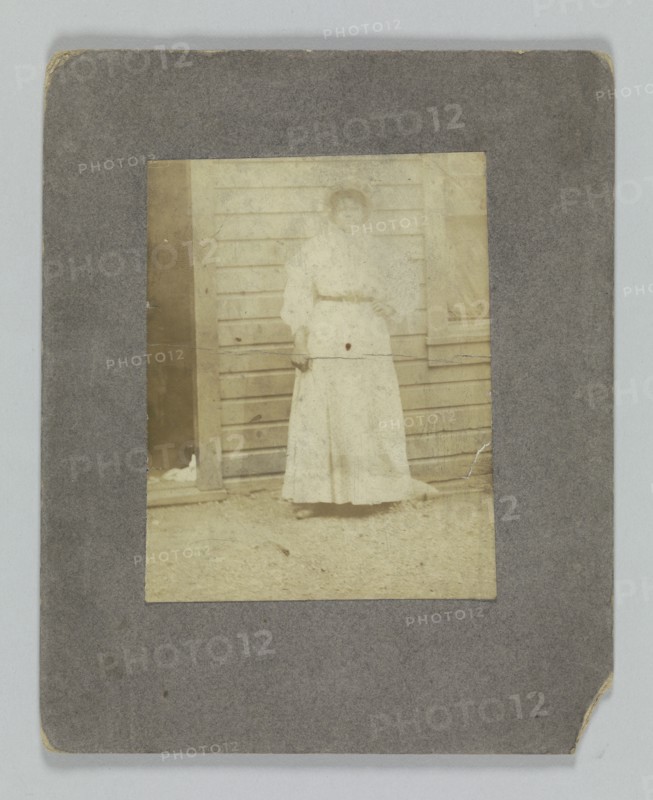 Photographic print of a woman in front of a building, late 19th century. Creator: Unknown.