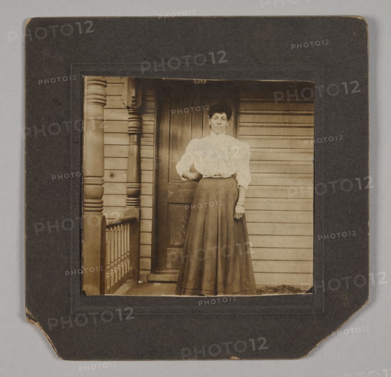 Photographic print of a woman on a porch, early 20th century. Creator: William O. Turner.