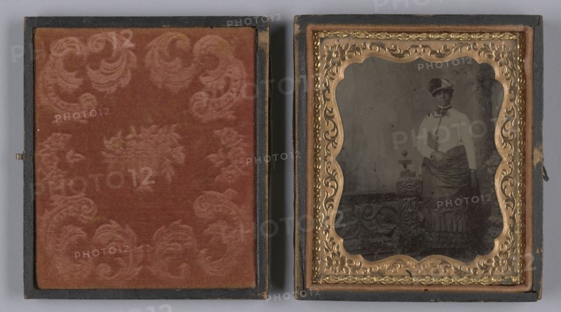 Tintype of a woman wearing a white hat and holding a book, 1880s. Creator: Unknown.
