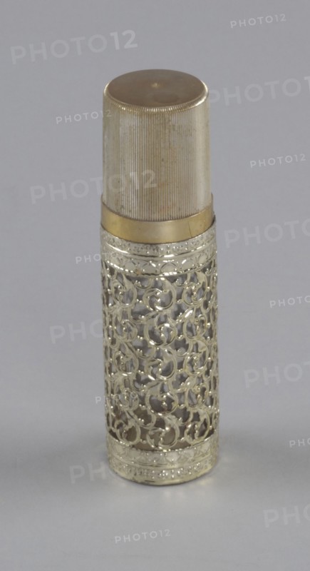 Gold and glass perfume bottle from Mae's Millinery Shop, 1941-1994. Creator: Anne Paree.