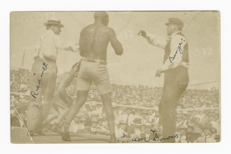 Photographic postcard of James J. Jeffries staggering away from Jack Johnson, 1910. Creator: Unknown.
