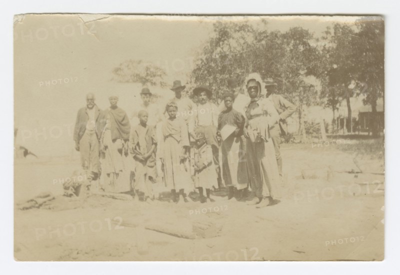Photograph of men, women, and children in a yard, early 20th century. Creator: Unknown.