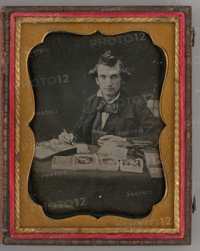 Untitled (Portrait of Seated Man Holding a Daguerreotype and Brush), 1865. Creator: Samuel J. Miller.