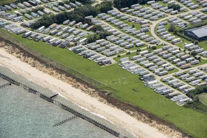 Coastal erosion between a caravan park and the sea defences at Corton Cliffs, Suffolk, 2019. Creator: Historic England.