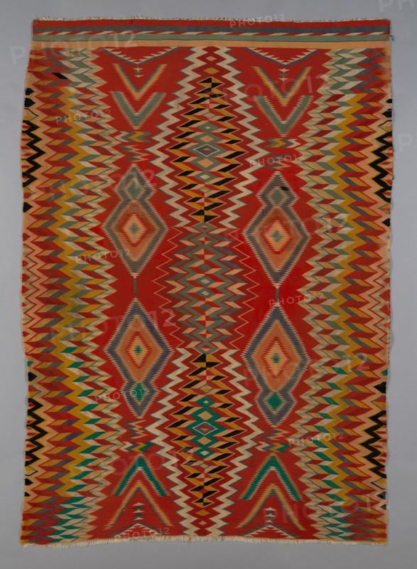 Germantown Eyedazzler Rug, Arizona, c. 1800/90. In 1864 the U.S. government forcefully resettled the Navajo in the Bosque Redondo reservation. The brightly coloured commercial yarns they received as part of their government annuities prompted a cultural and artistic transformation in their weaving, with bold designs incorporating serrated diamonds, chevrons, zigzags and interlocking lines.
