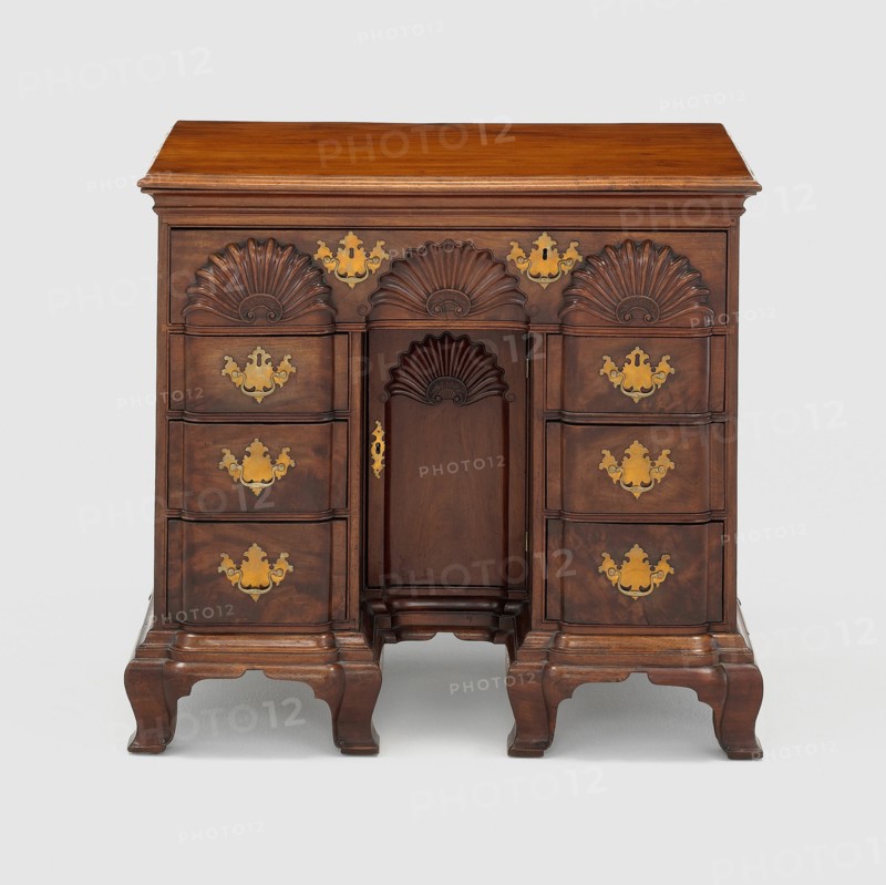 Bureau Table, c. 1770. Small wooden bureau with carved half-circle designs, gilded handles. Attributed to John Townsend.