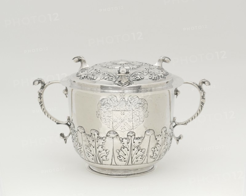 Two-Handled Covered Cup, 1698/1720. Silver cup with lid, two handles with leaf designs, used to serve syllabub, a sweetened or flavoured wine, cider, beer, or ale into which milk was whipped. Scroll-like handles, acanthus-leaf ornament.