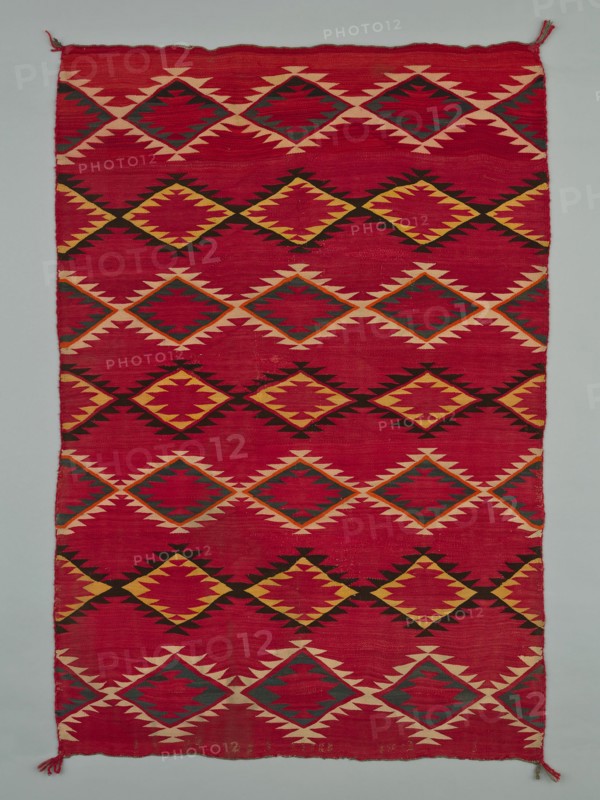 Sarape with Serrated Diamond Pattern, 1880/1900. A work made of wool, plain weave with "lazy lines" and dovetail tapestry weave; twined warp ends and selvages; looped and knotted corner tassels.