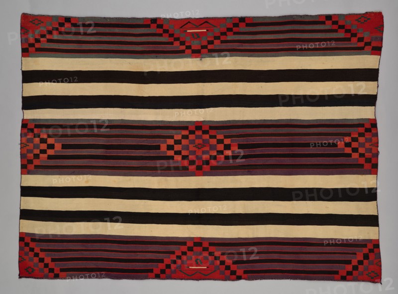 Chief Blanket (Third Phase), c. 1880. A work made of wool, plain weave with "lazy lines" and dovetail tapestry weave; warp and weft twining; corner tassles.