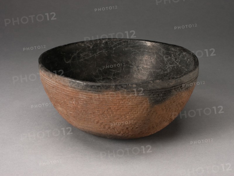 Bowl with Textured Surface Decoration in Basketry-Like Pattern, A.D. 900/1000. Round, red-brown bowl with small cracks its black interior. The outer surface is striated with tight horizontal lines and a diagonal pattern.