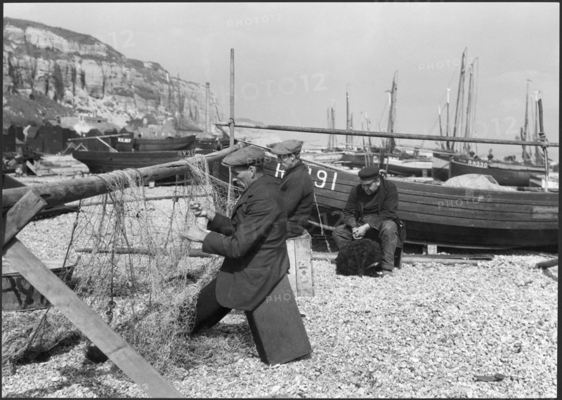 Fishermen mending nets on the beach, Hastings, East Sussex, 1925-1939. Creator: J Dixon Scott.