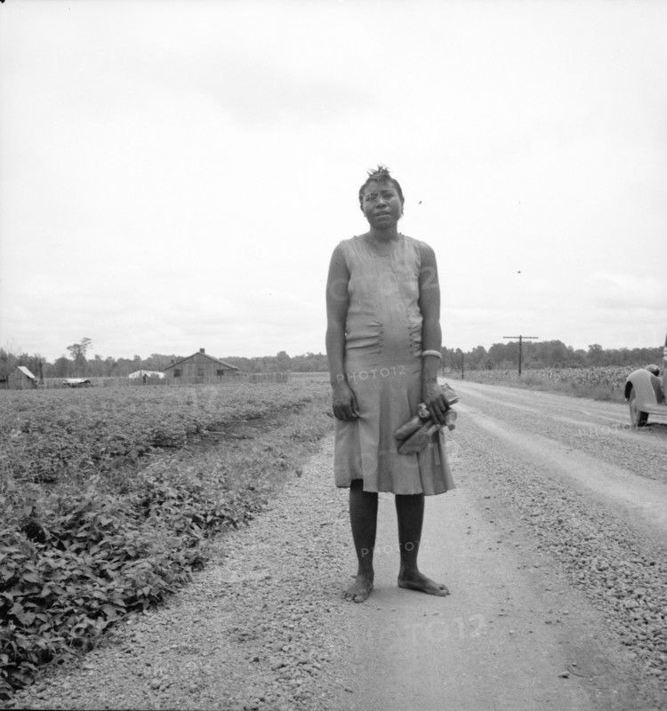 Negro woman carrying her shoes home from church, Mississippi Delta, 1936. Creator: Dorothea Lange.