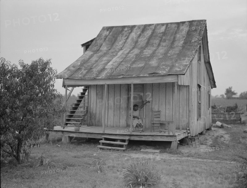 Cotton field hand sitting on her porch on Sunday afternoon, near Blytheville, Arkansas, 1937. Creator: Dorothea Lange.