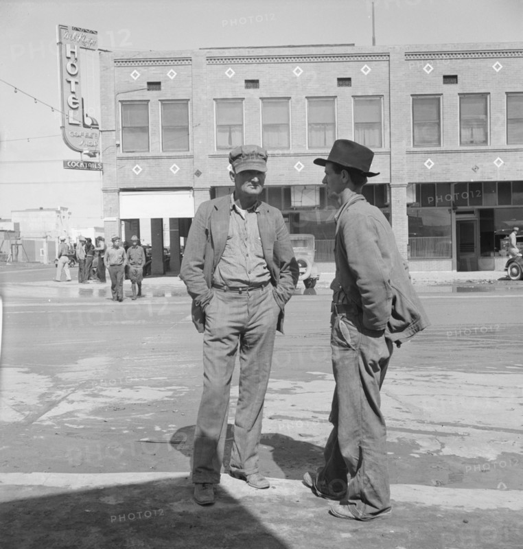 Idle pea pickers discuss prospects for work, Calipatria, Imperial Valley, California, 1939. Creator: Dorothea Lange.