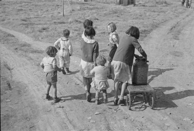 Children of migratory workers, hauling water, American River camp, San Joaquin Valley, CA, 1936. Creator: Dorothea Lange.
