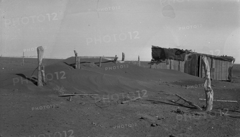 Fence corner and outbuilding being buried by dust, Mills, New Mexico, 1935. Creator: Dorothea Lange.
