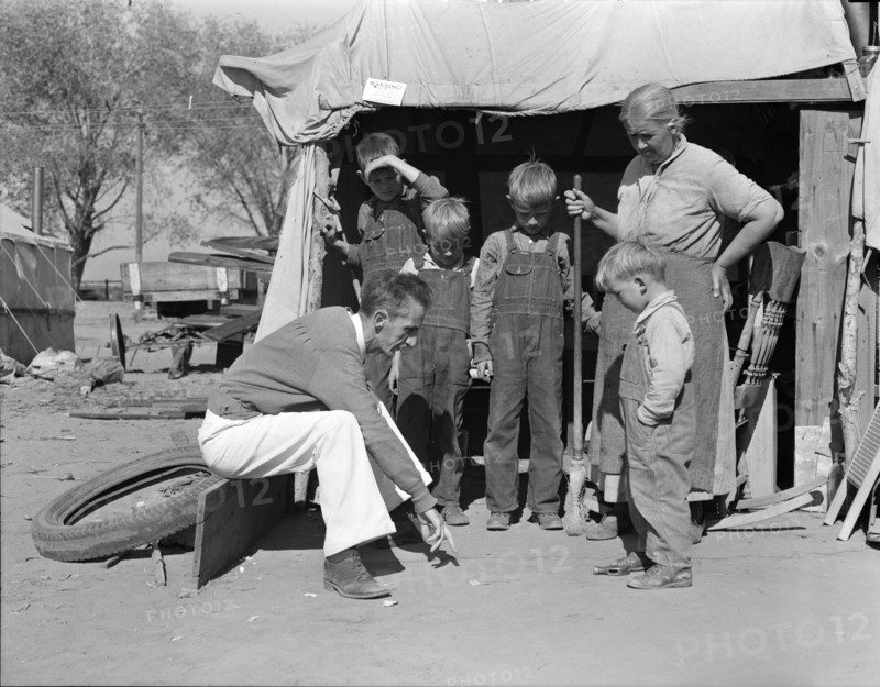 Tom Collins, manager of Kern migrant camp talking with drought refugee and her..., CA, 1936. Creator: Dorothea Lange.