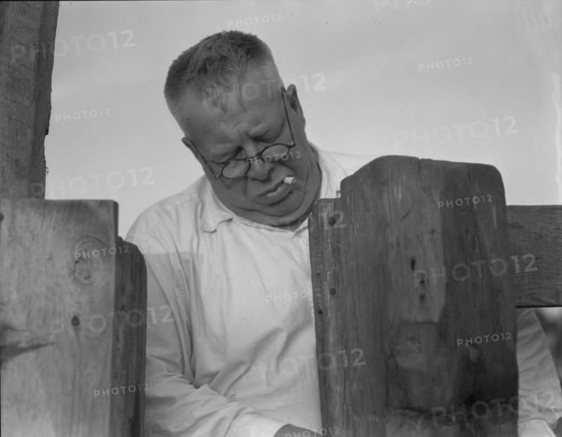 Henry Lotz closing the gate to the barns at the Midway City Dairy Association, near Santa Ana, 1937. Creator: Dorothea Lange.