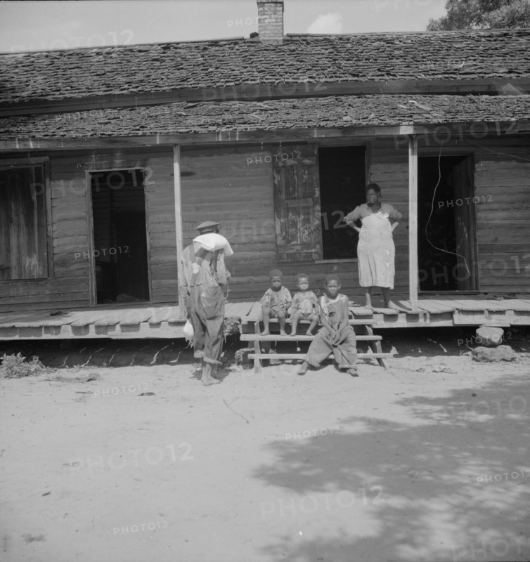 Negro wage laborer and part of his family, Macon County, Georgia, 1937. Creator: Dorothea Lange.