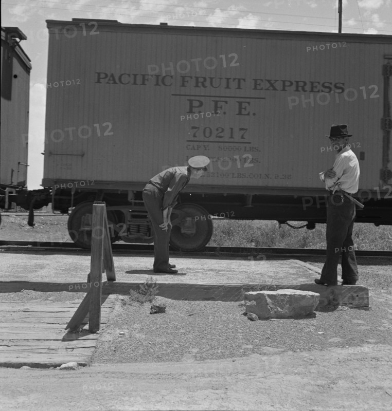 Inspecting a freight train from Mexico for smuggled immigrants, El Paso, Texas, 1938. Creator: Dorothea Lange.