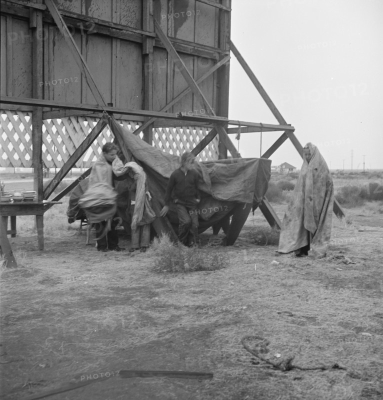 One of three families camped behind a billboard on U.S. 99, Kern County, California, 1938. Creator: Dorothea Lange.