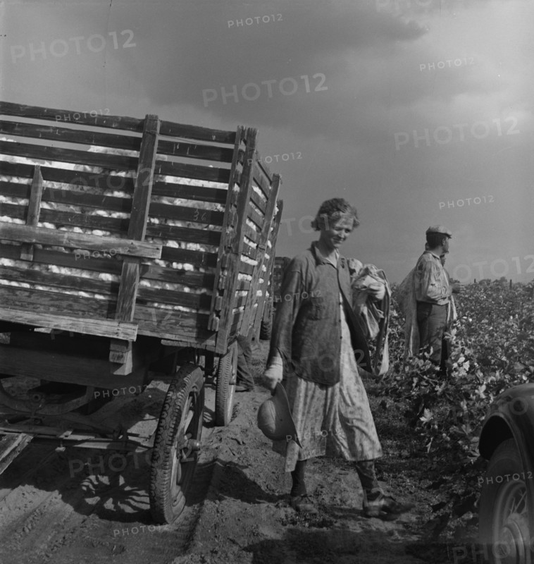 Migratory cotton pickers have stopped working because it started to rain, Kern County, CA, 1938. Creator: Dorothea Lange.