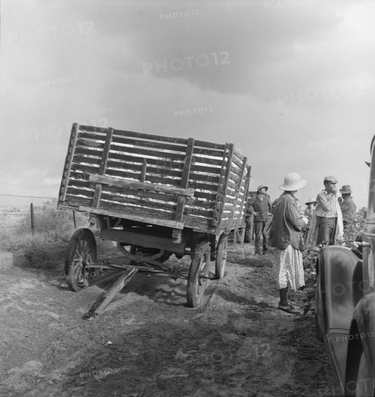 Migratory cotton pickers have stopped working because it started to rain, Kern County, CA, 1938. Creator: Dorothea Lange.
