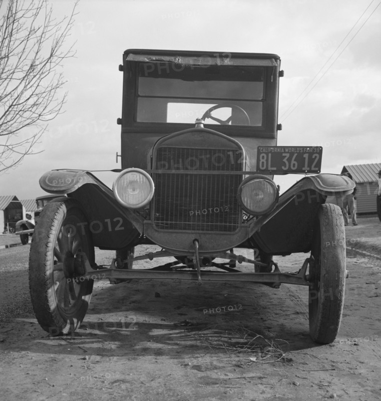 Model T Fords still carry migrants, FSA migratory labor camp at Farmersville, California , 1939. Creator: Dorothea Lange.