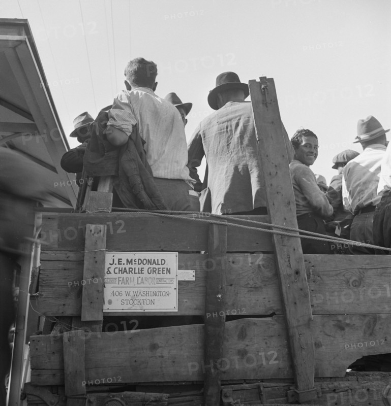 Labor contractor's truck with gang of pea pickers pulled up for gas, Westley, California, 1939. Creator: Dorothea Lange.