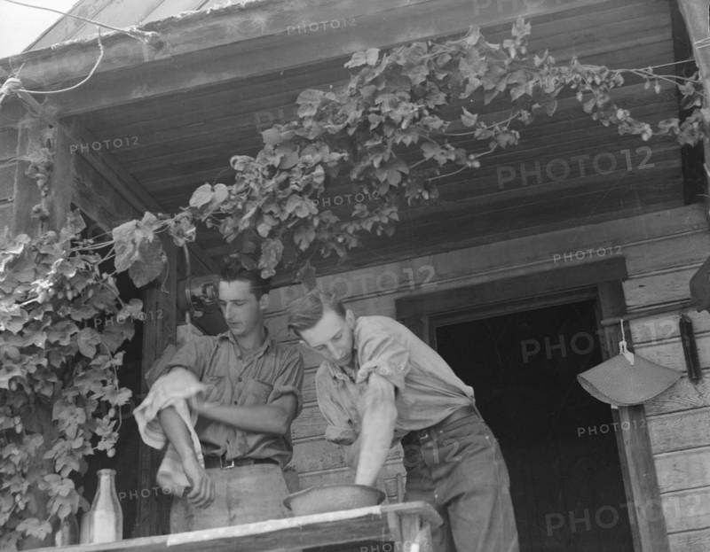 Hop farmer's sons, washing for noon meal on back porch, Independence, Polk County, Oregon, 1939. Creator: Dorothea Lange.