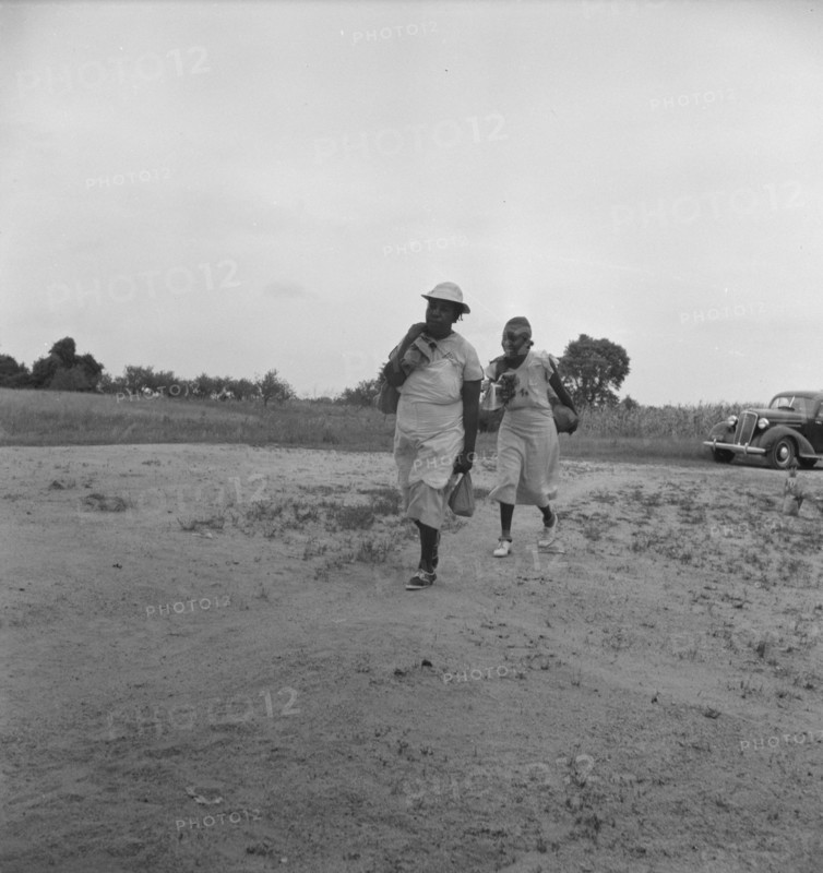 Mother of sharecropper family and friend...in the rain, Person County, North Carolina, 1939. Creator: Dorothea Lange.