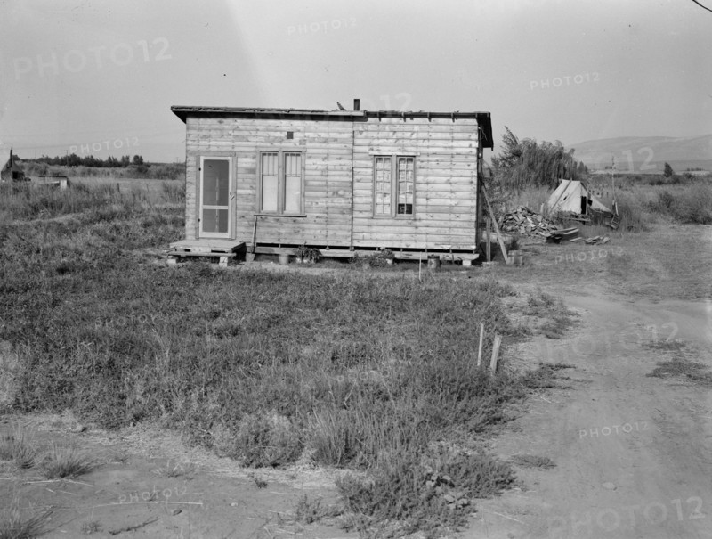 Homes are built bit by bit with whatever materials are available, Yakima,Washington, 1939. Creator: Dorothea Lange.