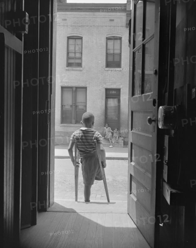Young boy standing in the doorway of his home on Seaton Road...,Washington, D.C, 1942. Creator: Gordon Parks.