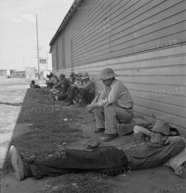 Idle men seated in shade on the other side of..., Tulelake, Siskiyou County, California, 1939. Creator: Dorothea Lange.