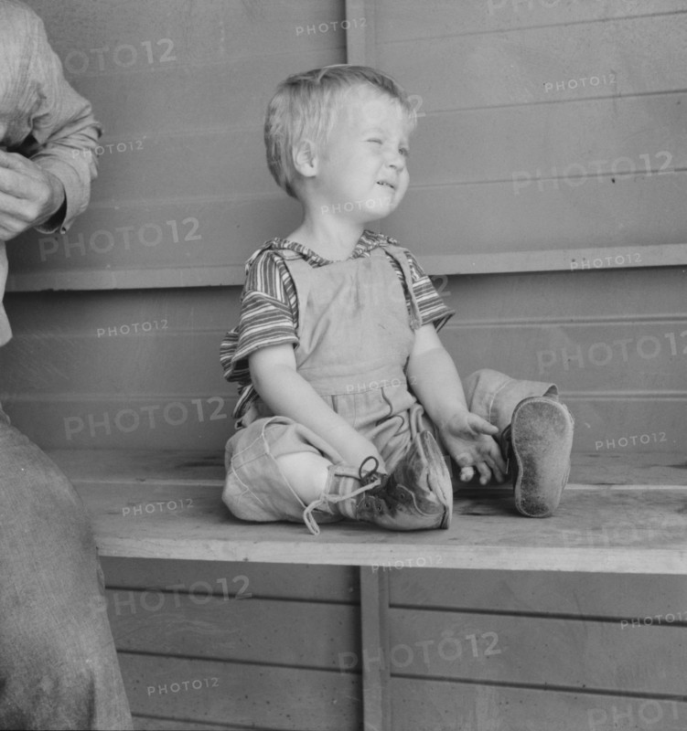 Baby with club feet wearing homemade splints, FSA camp, Tulare County, California, 1939. Creator: Dorothea Lange.