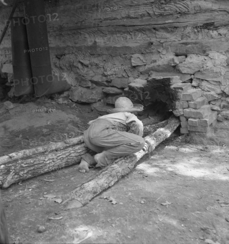 Ten year old son of tobacco tenant tends the fire..., Granville County, North Carolina, 1939. Creator: Dorothea Lange.