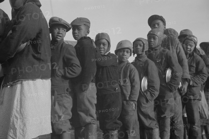 Possibly: Negroes in the lineup for food at the flood refugee camp, Forrest City, Arkansas, 1937. Creator: Walker Evans.
