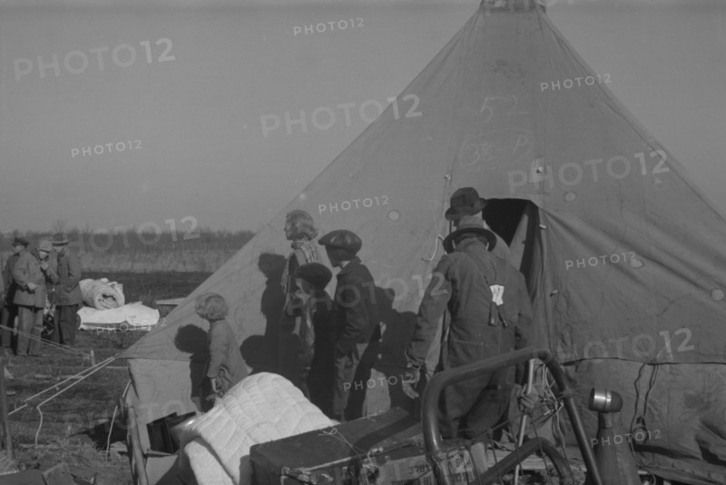 Possibly: Setting up a tent in the camp for white flood refugees, Forrest City, Arkansas, 1937. Creator: Walker Evans.