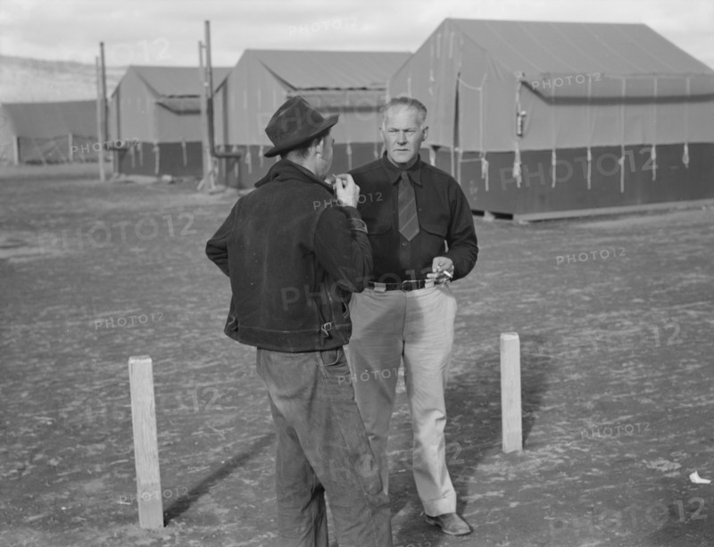 Camp manager talking to another man, FSA mobile camp, Merrill, Klamath County, Oregon, 1939. Creator: Dorothea Lange.