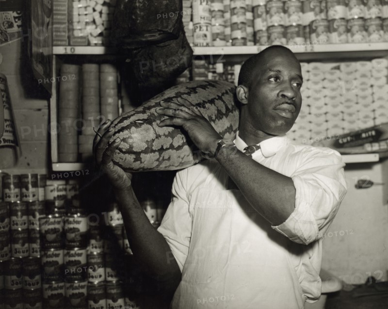 Mr. J. Benjamin, owner of the grocery store patronized by Mrs. Ella Watson..., Washington, DC, 1942. Creator: Gordon Parks.