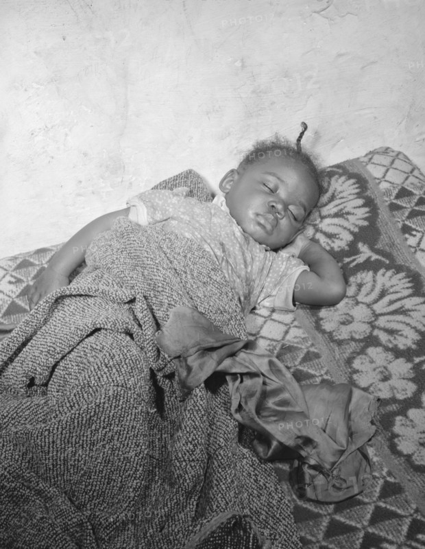 Child seriously ill from an infection caused by a rat bite in her home..., Washington, D.C., 1942. Creator: Gordon Parks.