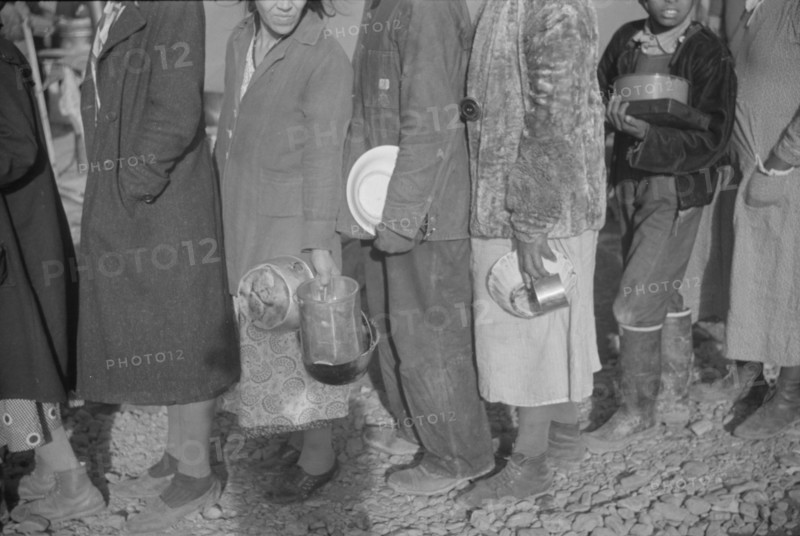 Possibly: Negroes at mealtime in the flood refugee camp, Forrest City, Arkansas, 1937. Creator: Walker Evans.