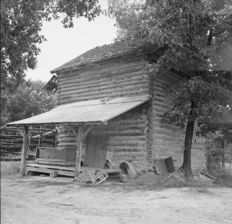 Tobacco barn with tobacco sled and vehicle..., Person County, North Carolina, 1939. Creator: Dorothea Lange.