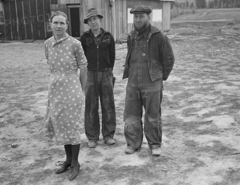 The mother, father, and hardworking fifteen-year-old son in yard..., Boundary County, Idaho, 1939. Creator: Dorothea Lange.