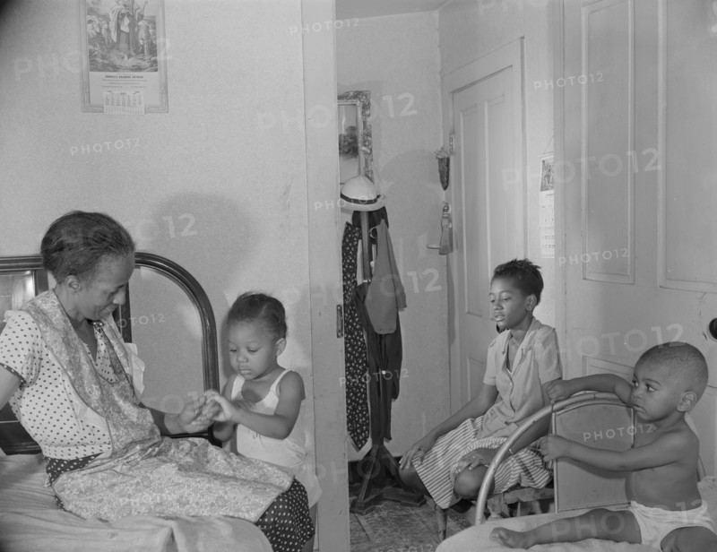 Adopted daughter and two grandchildren with Mrs. Ella Watson...charwoman, Washington, D.C, 1942. Creator: Gordon Parks.