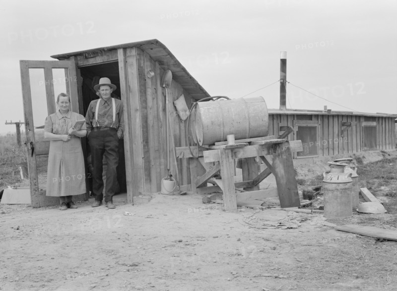 Mr. and Mrs. Wardlow at entrance to their dugout...home, Dead Ox Flat, Malheur County, Oregon, 1939. Creator: Dorothea Lange.