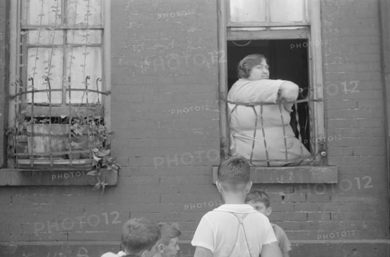 New York, New York. 61st Street between 1st and 3rd Avenues. Children playing in the street.