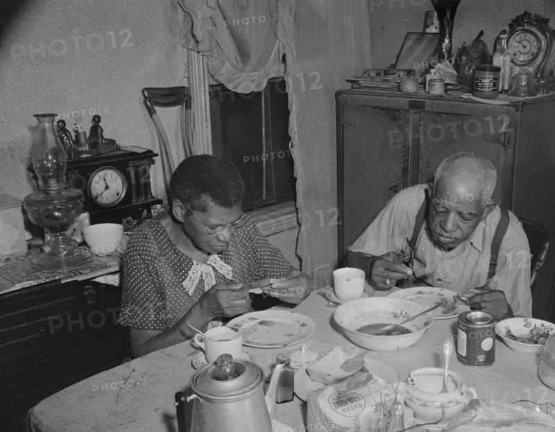 Washington, D.C. Elderly couple eating dinner at their home on Lamont Street, N.W..