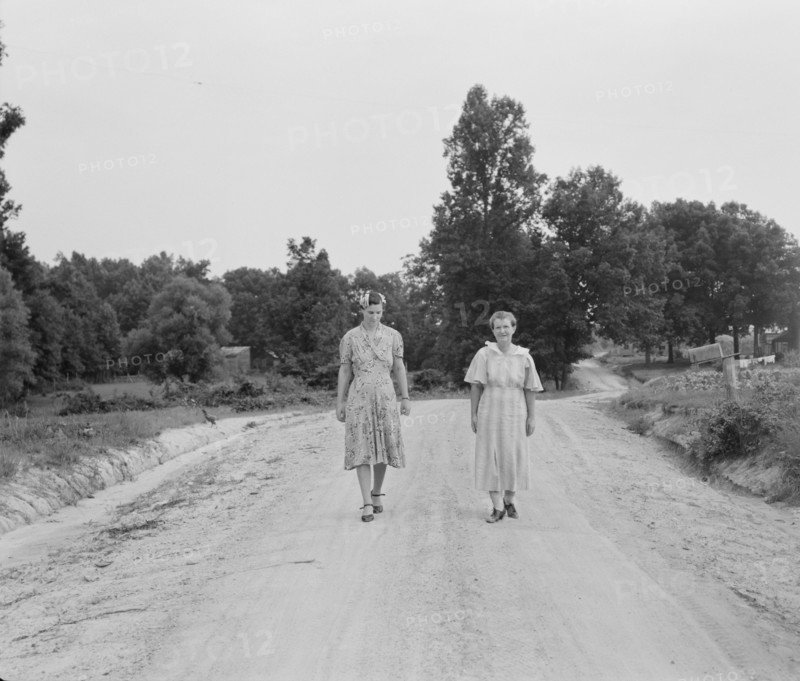Women walking down the road to see a sick neighbor. Person County, North Carolina.